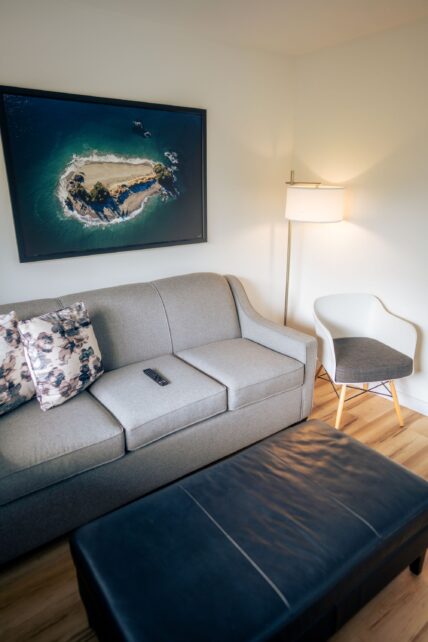 Hotel room living area with pull out couch, art, and ottoman