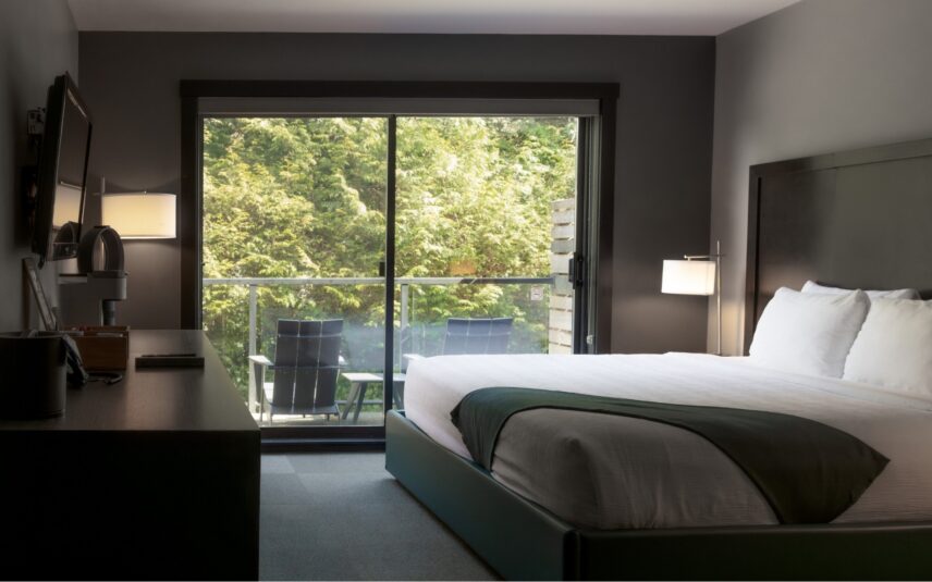 King bed in cozy room with ocean-inspired artwork above the headboard