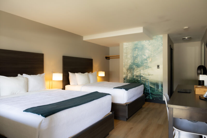 Spacious hotel room with two queen beds and Tofino Resort + Marina forest photography piece