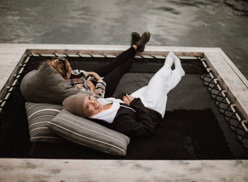 Two women relaxing in cozy hammocks at the floating sauna dock in Tofino