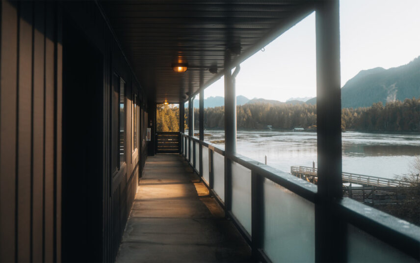 Covered walkway leading to rooms with panoramic views of Tofino Harbour and mountains