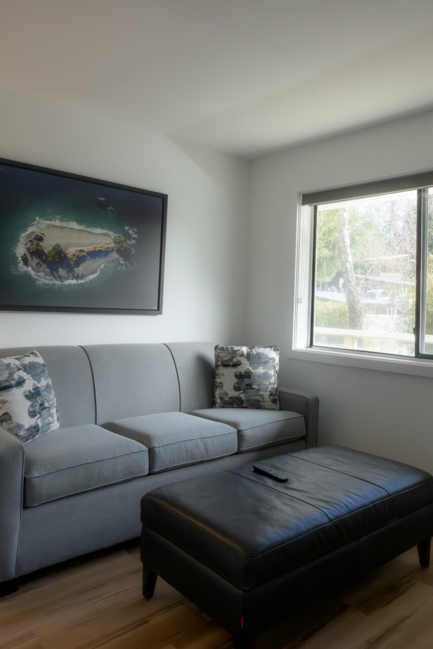 Hotel room living area with pull out couch, art, and ottoman