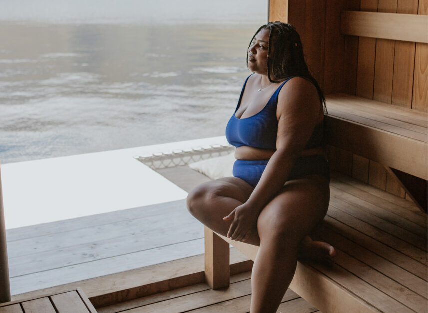Woman relaxing inside the floating sauna surrounded by natural West Coast beauty