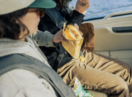 Lady holding a sandwich on a boat tour in Tofino