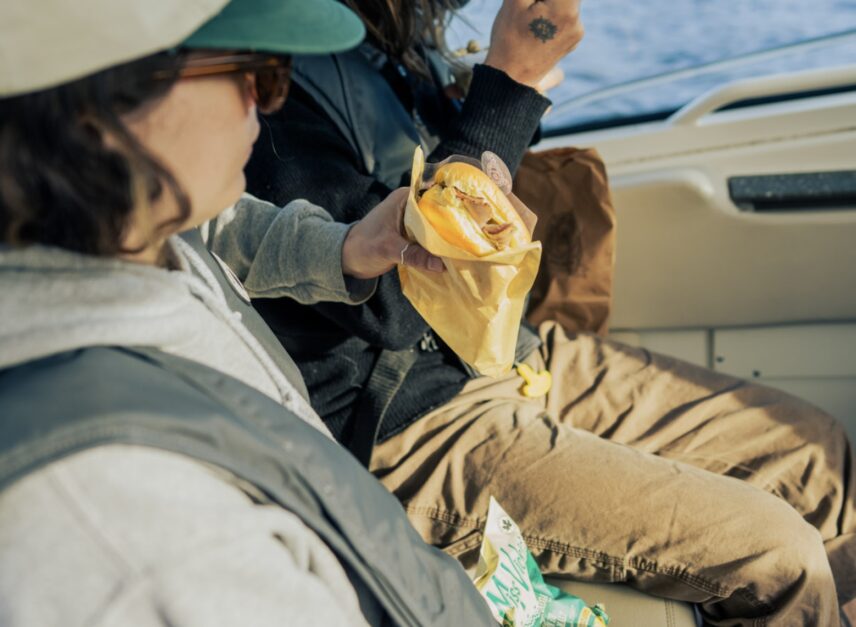 Lady holding a sandwich on a boat tour in Tofino