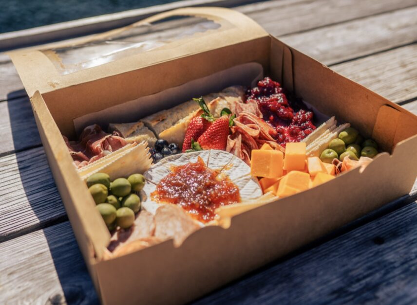 A shot of a grazing board that includes meats, chesses, olives, fruit, etc