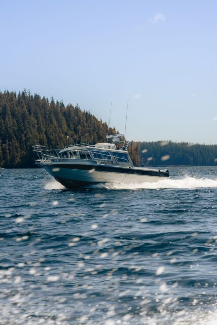 Boat driving up the inlet as part of tofino hotel and adventure packages