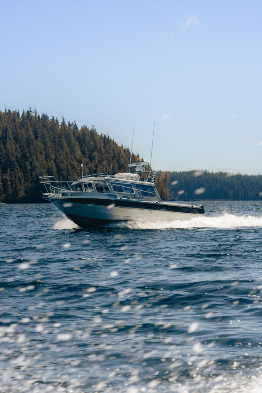 Boat driving up the inlet as part of tofino hotel and adventure packages