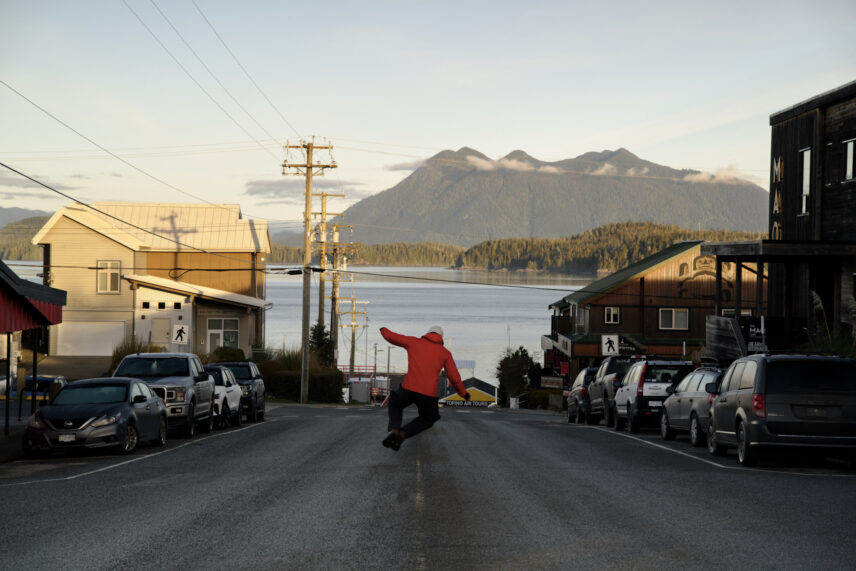 man jumping down the road in tofino with an ocean view