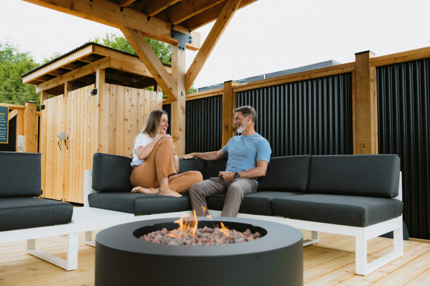 couple sitting on an outdoor deck enjoying a fire pit in tofino